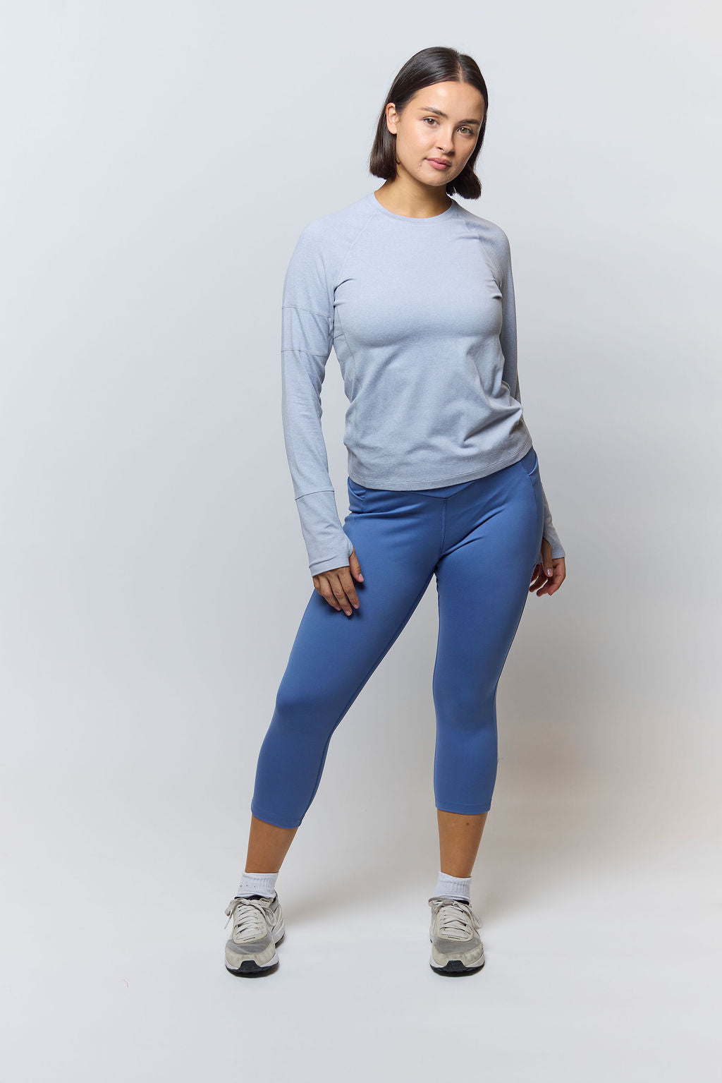 Light gray Foudy 2.0 long-sleeve top, full-length view with blue cropped leggings