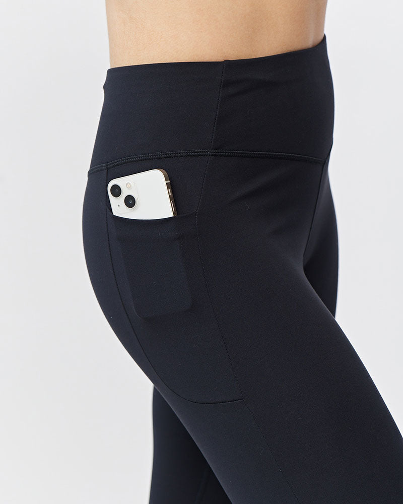 Black Go Again cropped leggings, close-up of the side pocket holding a phone