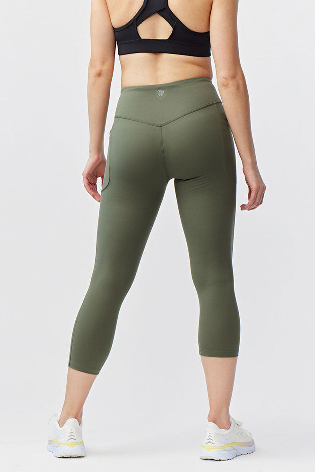 Olive green Go Again cropped leggings, back view showing the waistband and calf-length hems