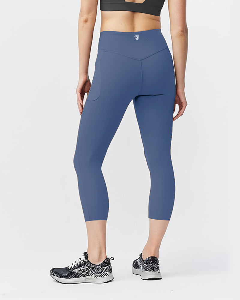 Back view of a model wearing blue Goal Five Go Again cropped leggings