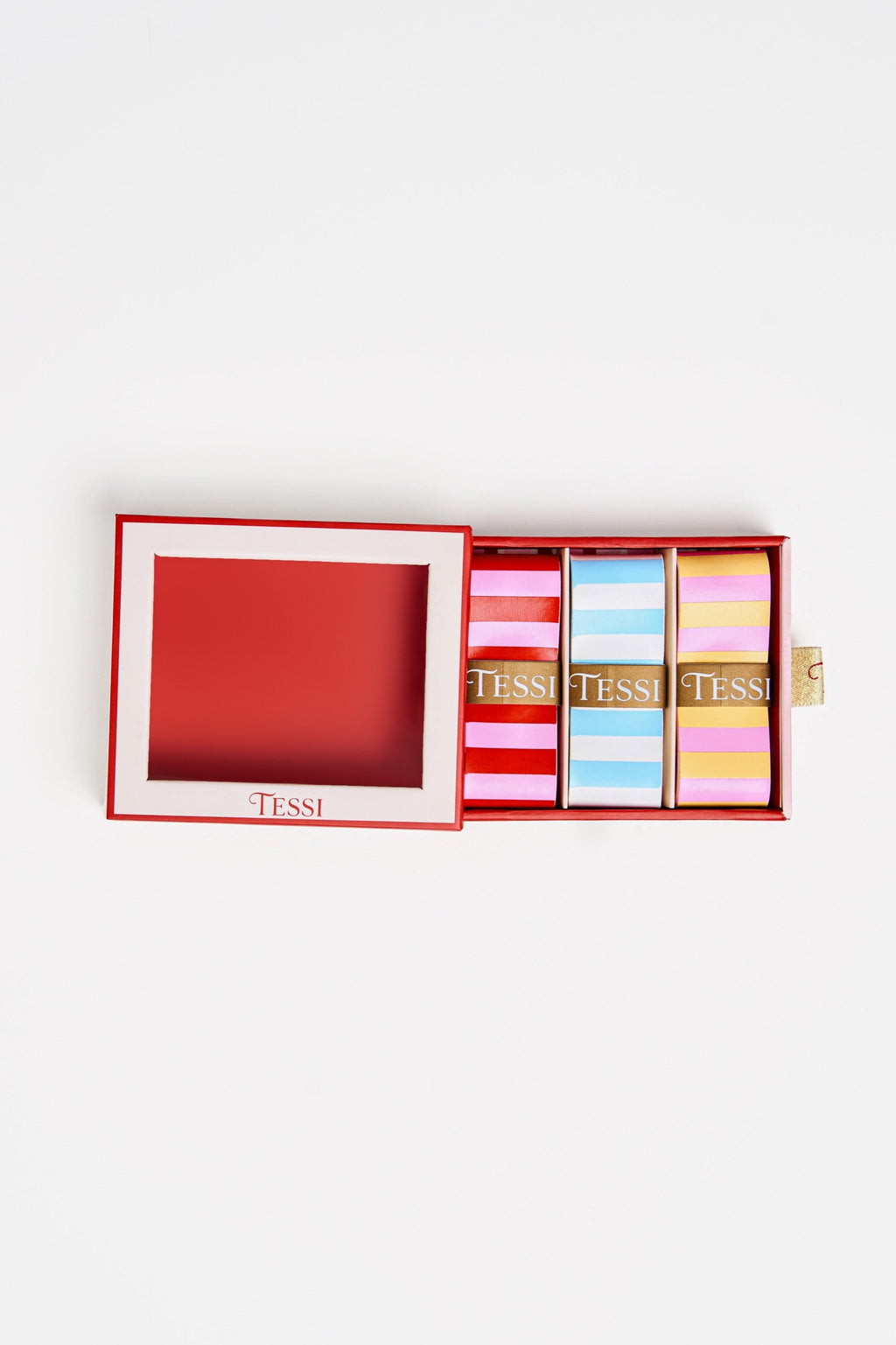 Open TESSI box with three overgrips striped pink and red, blue and white, and yellow and pink