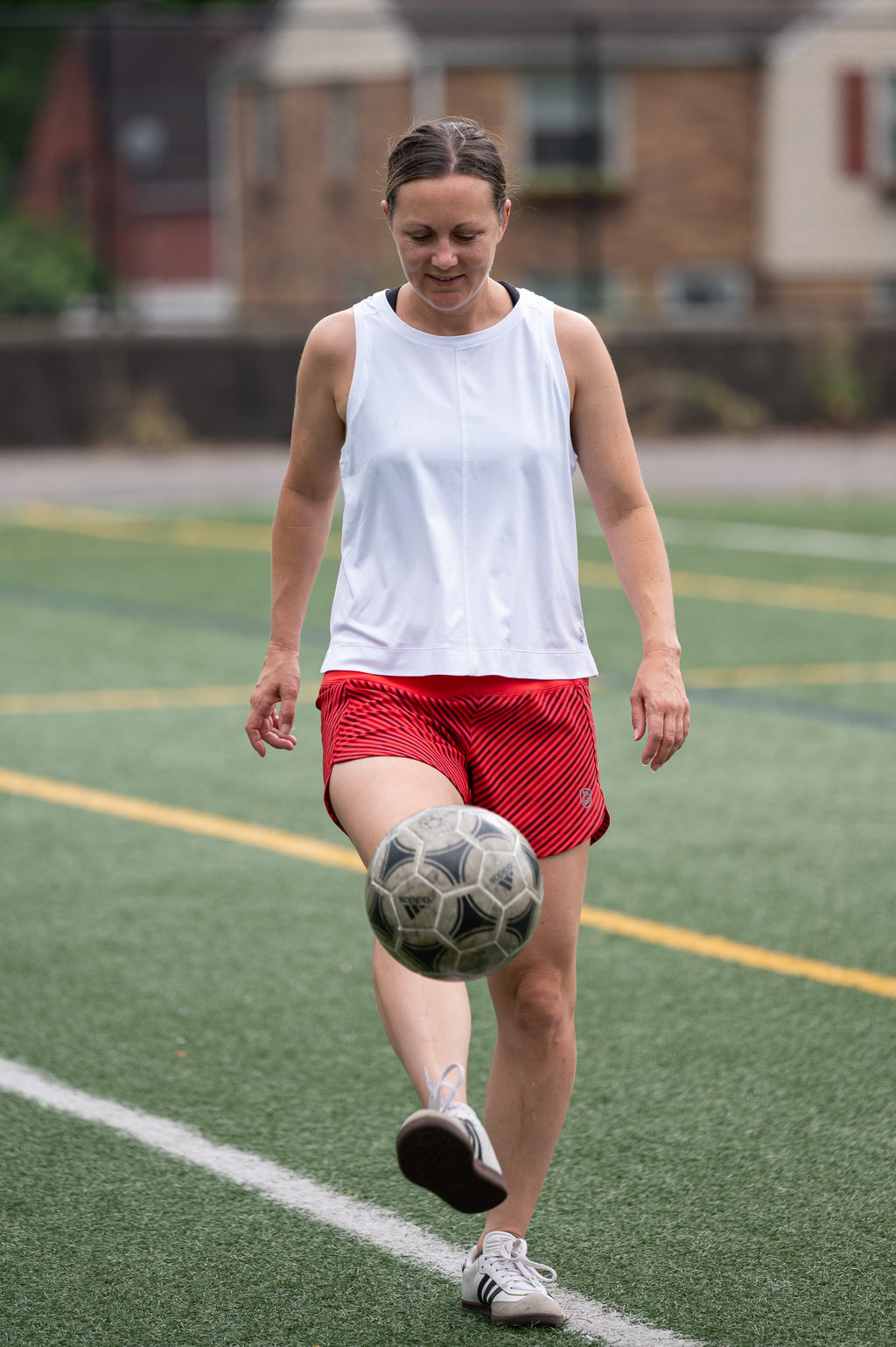 White Boxy Crop Tank worn while juggling a soccer ball on a turf field